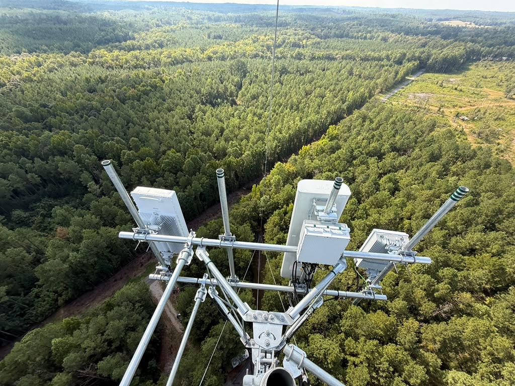 Completed 5G equipment installation on a Verizon tower in a wooded area