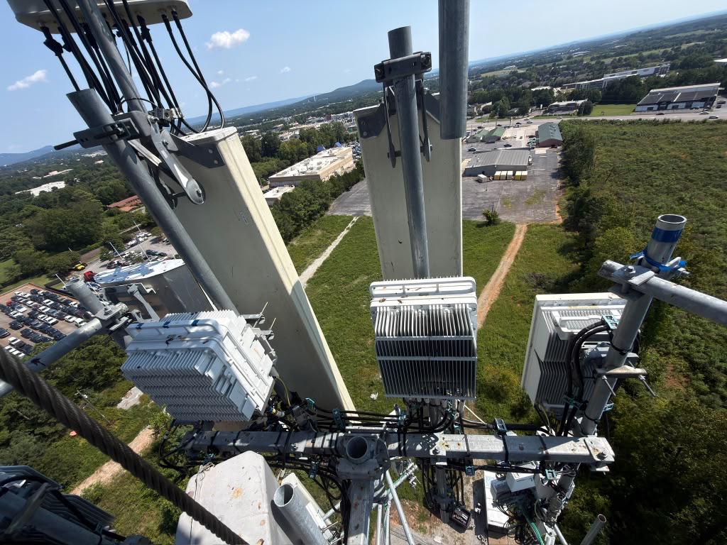Verizon tower antenna mount before 5G equipment installation, overlooking a commercial area